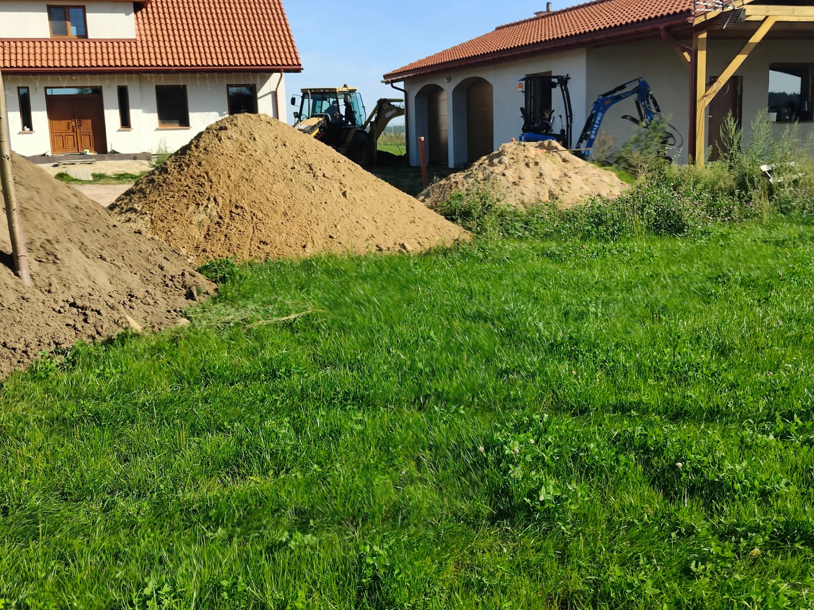 Hałdy ziemi po wykopach przy domu